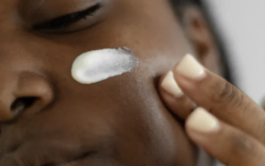 Woman applying lotion to her face