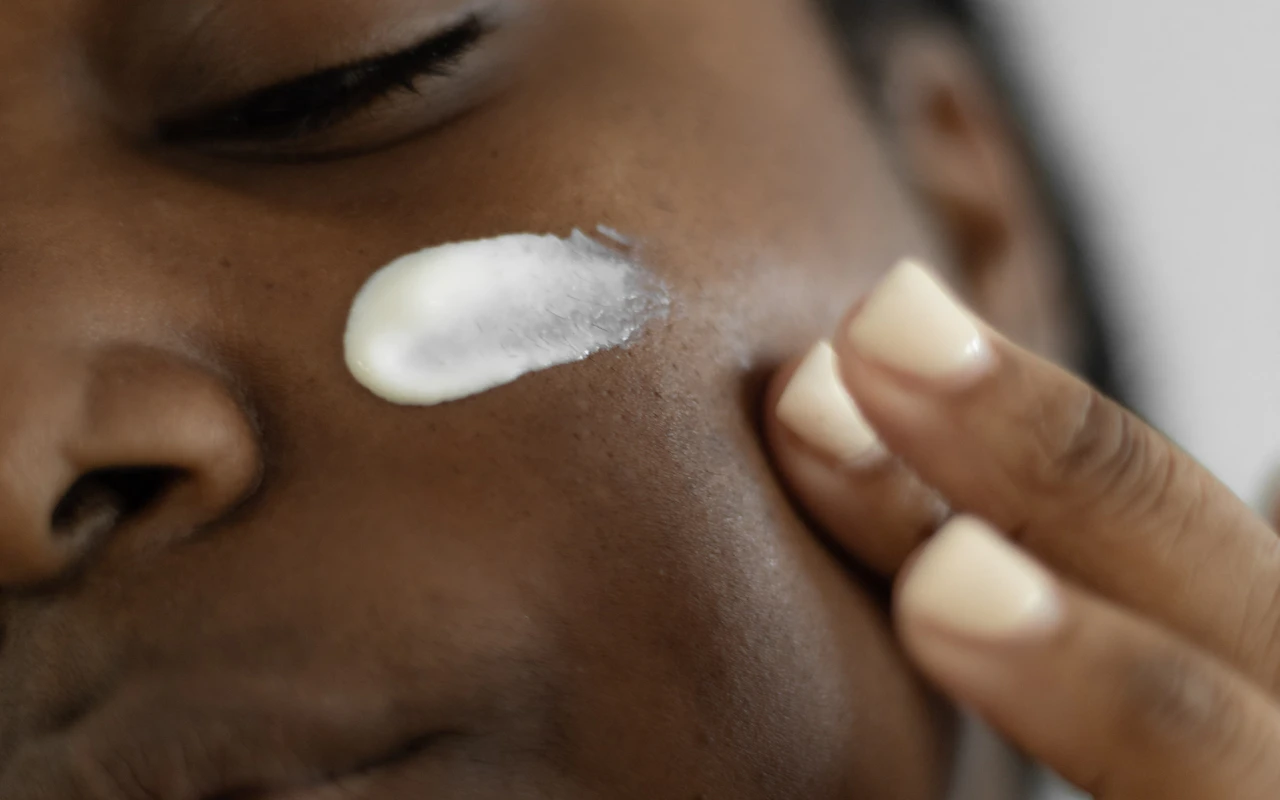 Woman applying lotion to her face
