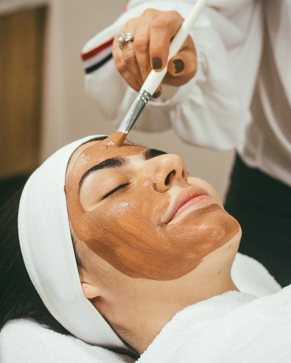 Woman receiving a facial mask treatment