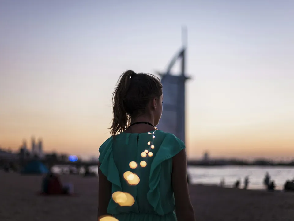 Woman looking at the Dubai skyline at sunset