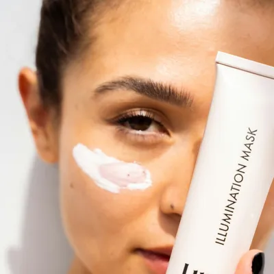 Woman applying skincare to her cheek